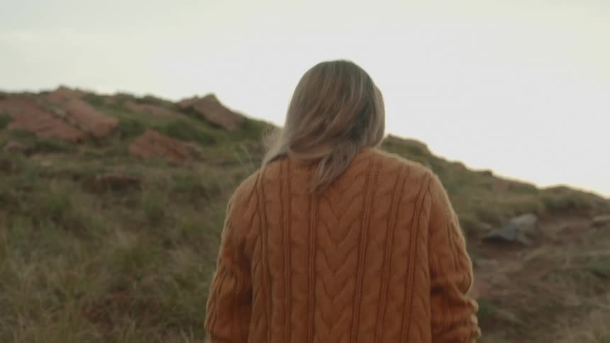 A young woman walks up a hill