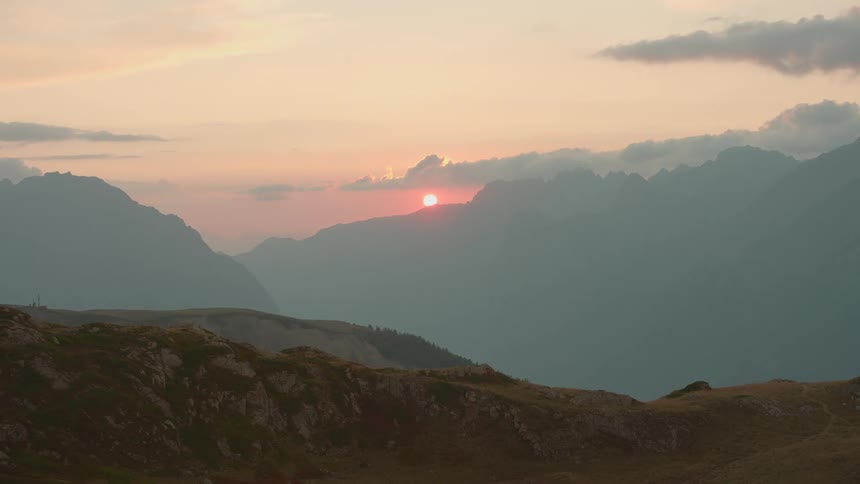 Sun setting in a red sky over the mountain range
