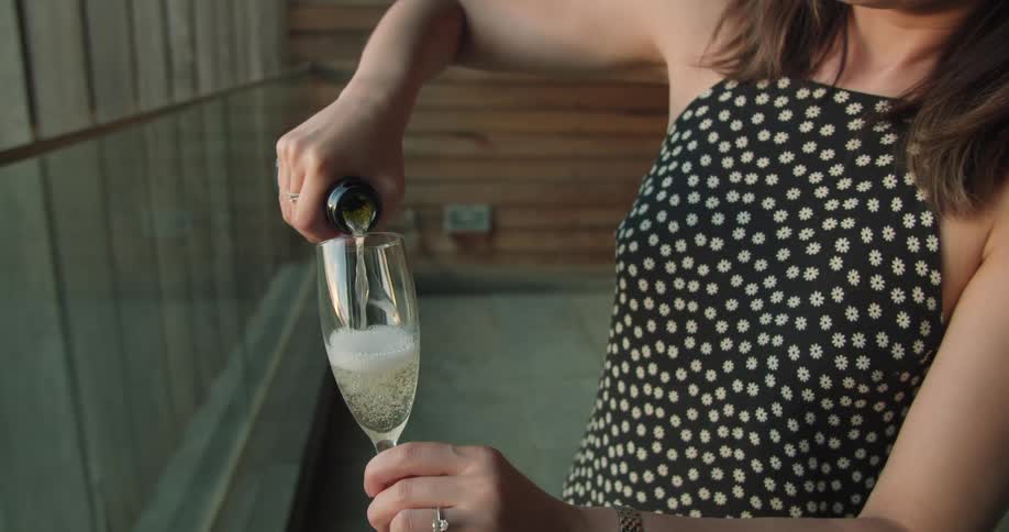 A woman pouring a glass of champagne