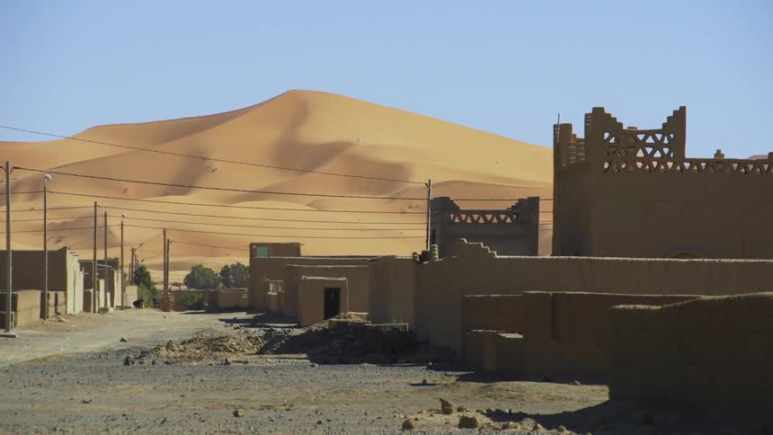 A large sand dune is outside of the city