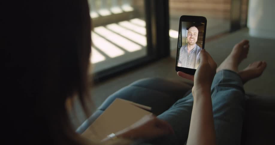 Friends saying hello on a video call through a smartphone at home