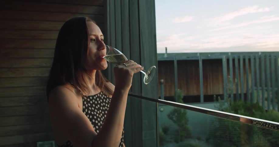 A woman drinking on a patio