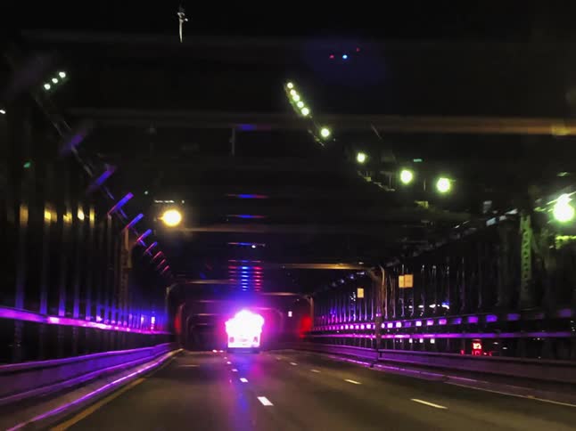 An ambulance is speeding over the bridge