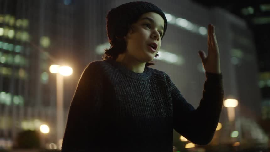 A boy is talking at night in the city