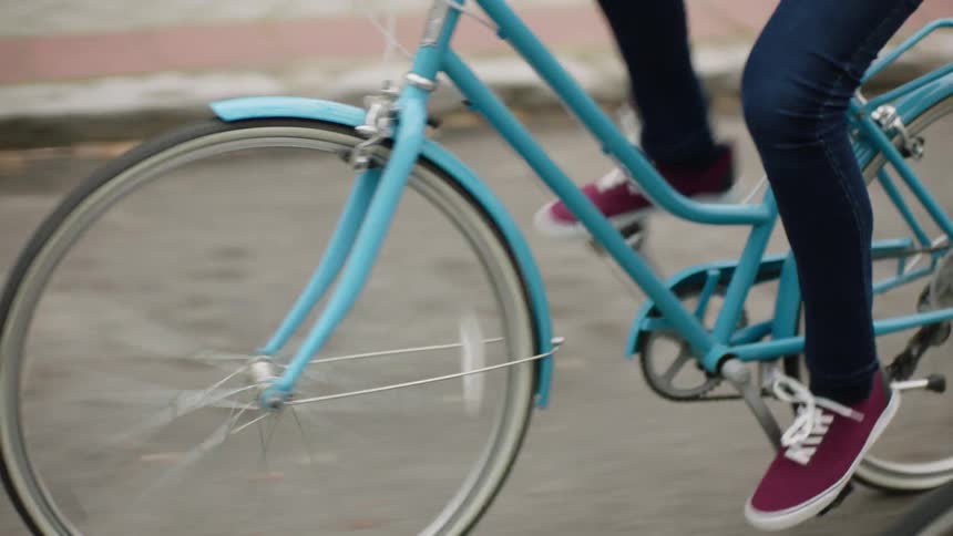 A girl is riding a bicycle on a road during the day