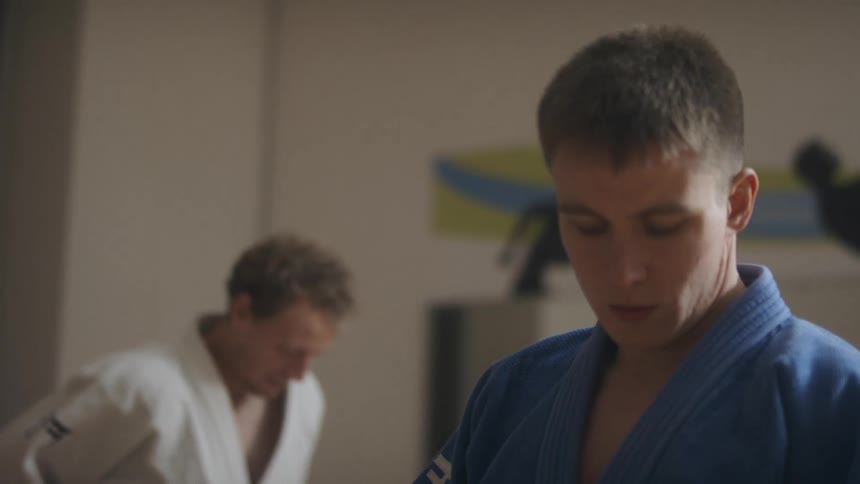 Two men put on their karate uniforms