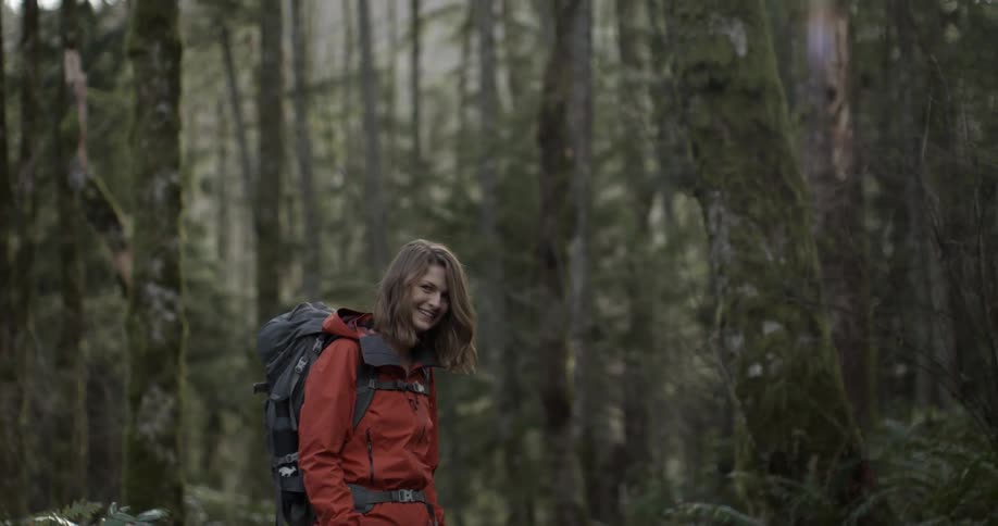 Smiling female hiker standing in the wilderness
