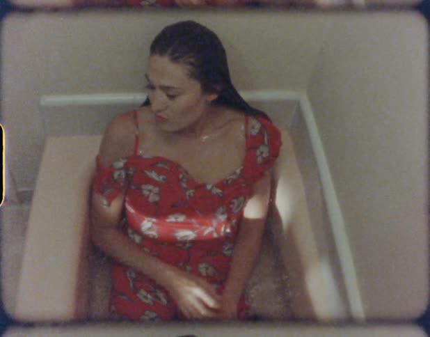 A woman with a dress sitting in a bathtub with water