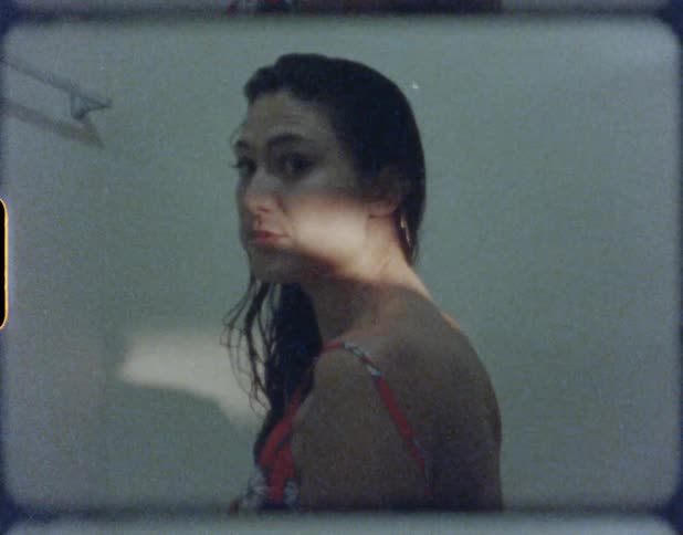A woman with a dress standing in a room with the sunlight shining on her face