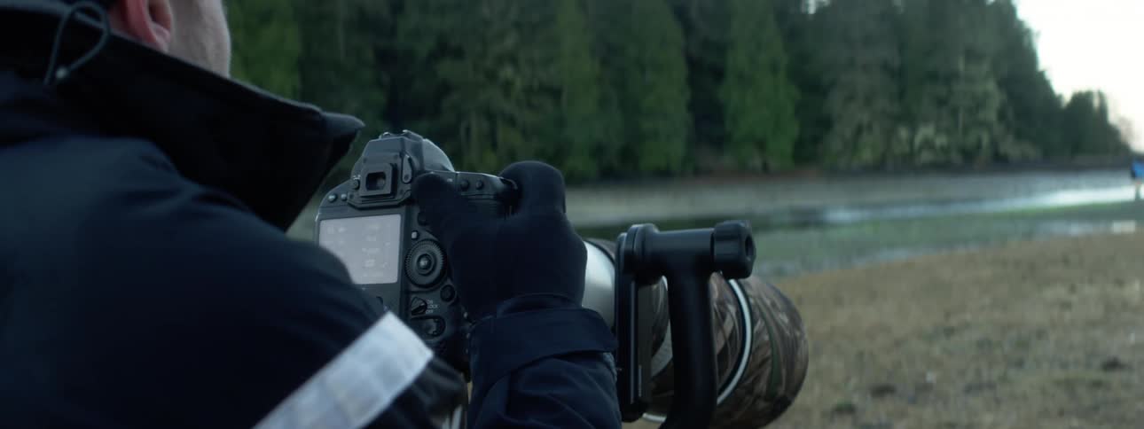 A man is taking pictures with a camera outdoors in spring