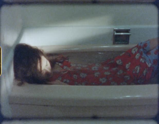A woman is laying in a bathtub during the day
