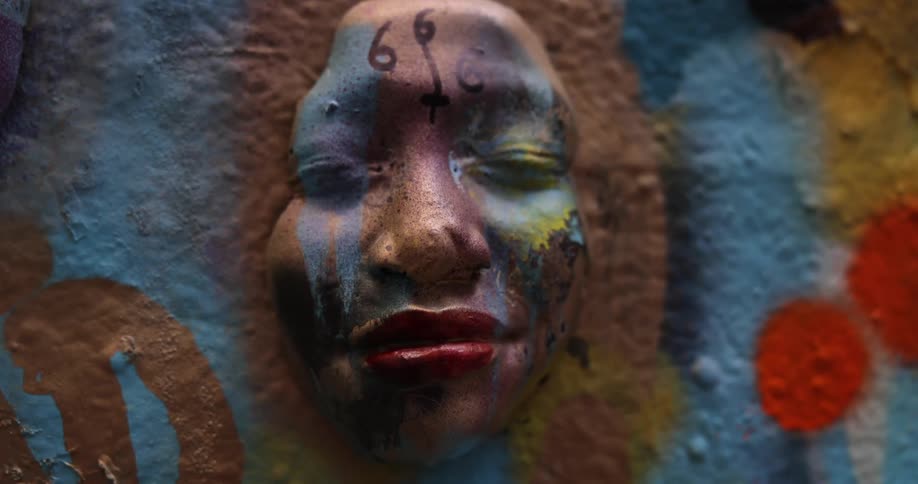 Close up of the face of a woman with her eyes closed coming out of a colorful wall