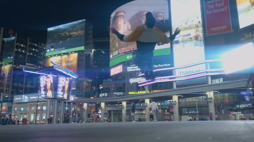A man doing flips in a ad laden city