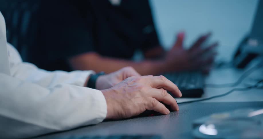 Elderly hands control a computer mouse