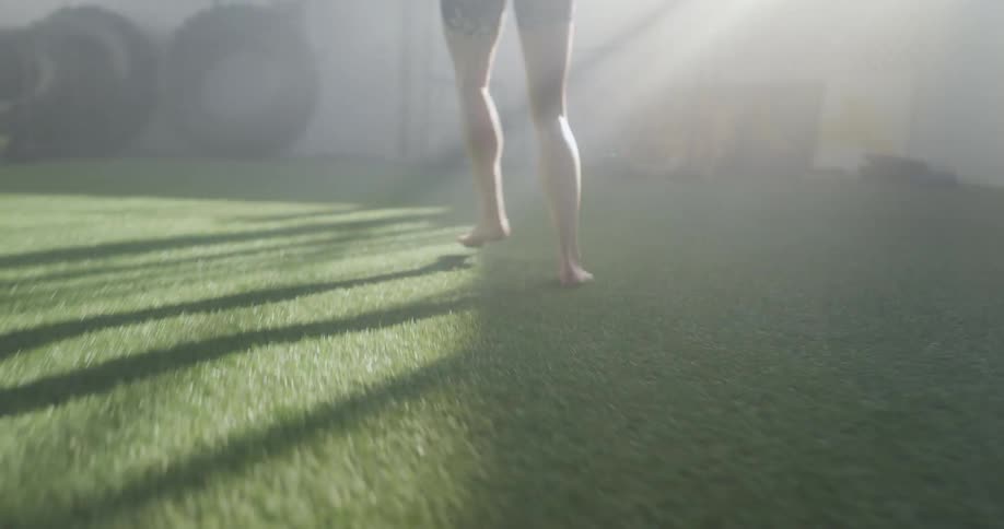 A woman practices her footwork skipping across the turf in a gym
