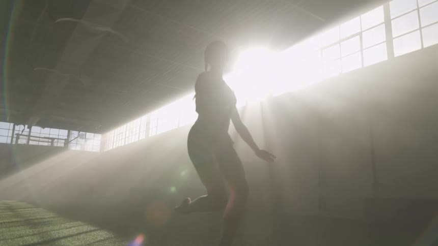 A woman leaps across the turf stretching into split position in the air