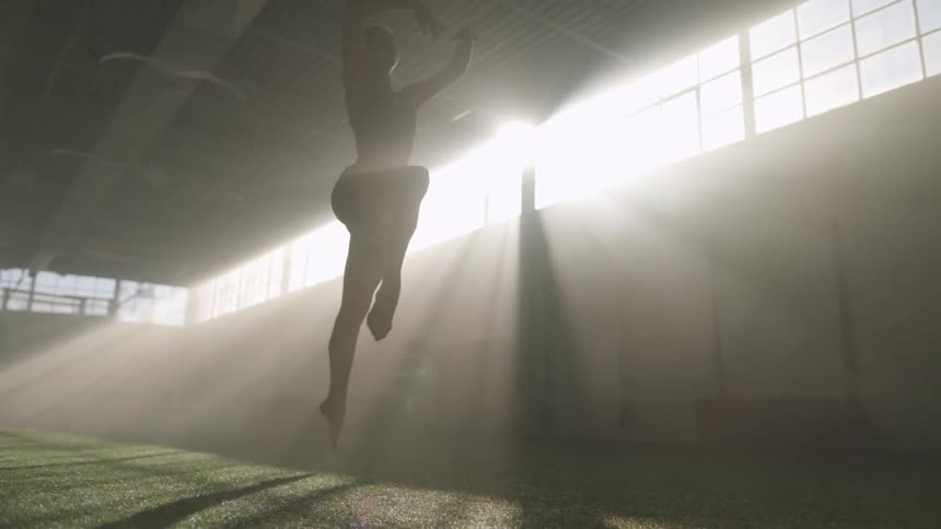 A gymnast runs and leaps