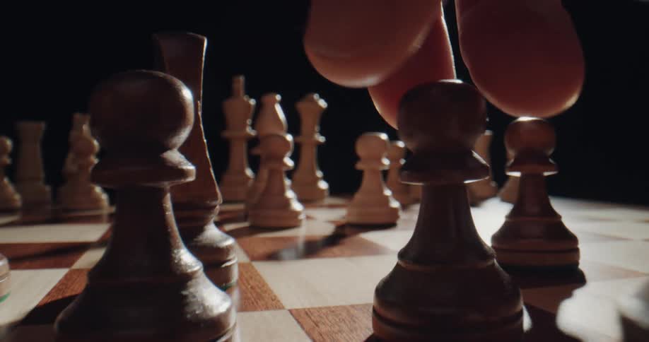 A chess player moves a pawn forward on the chessboard