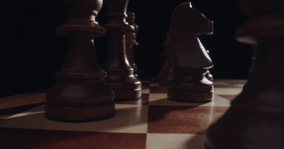 A person moves a chess piece on a board