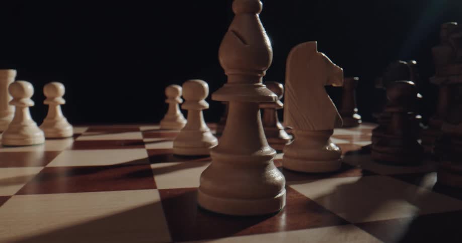 A person moving chess pieces on a chess board