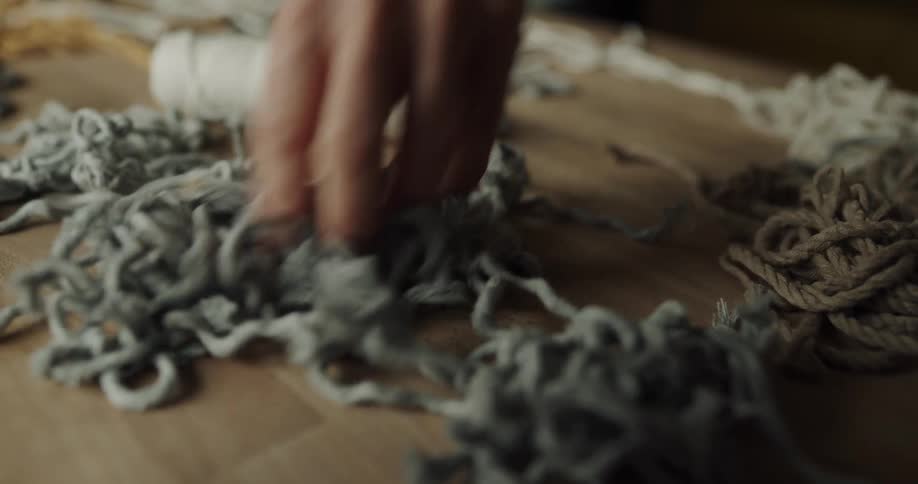 A person is holding yarn on a table