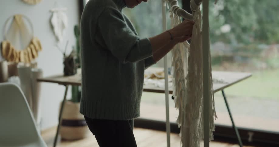 A woman is crafting yarn while indoors during spring