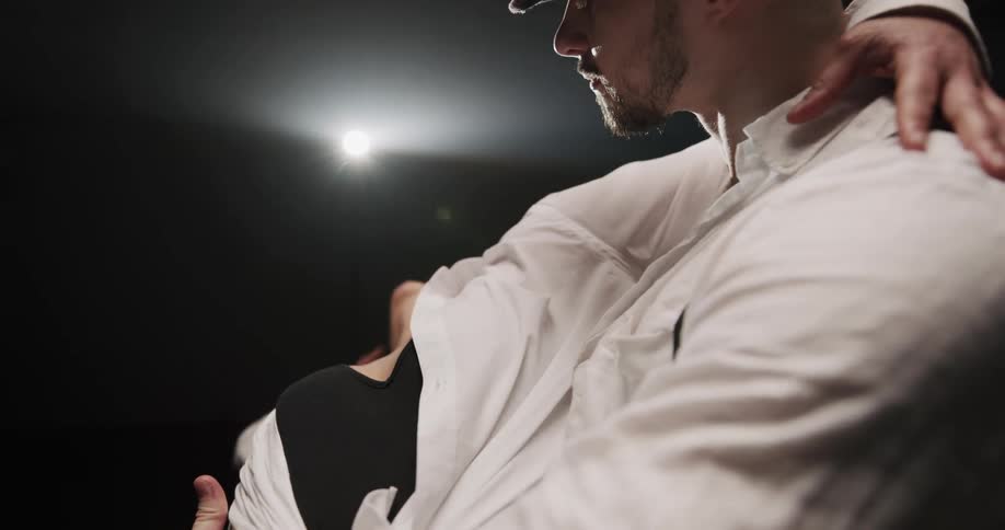 A man and woman dance under a bright spotlight