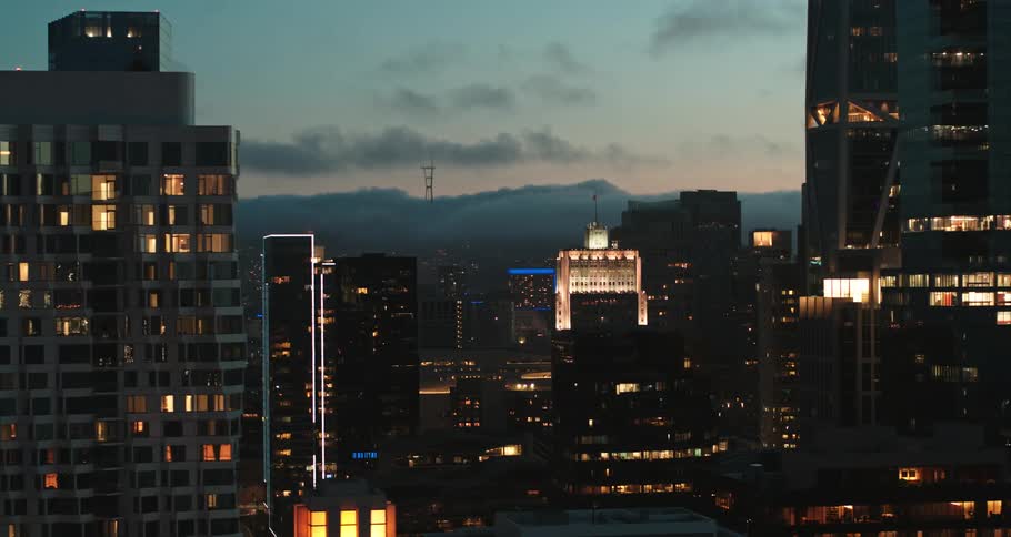 An aerial view of office buildings and high rises in a downtown area at dusk