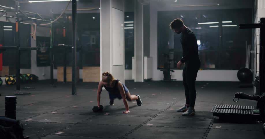 A man and woman working out in a gym with weights