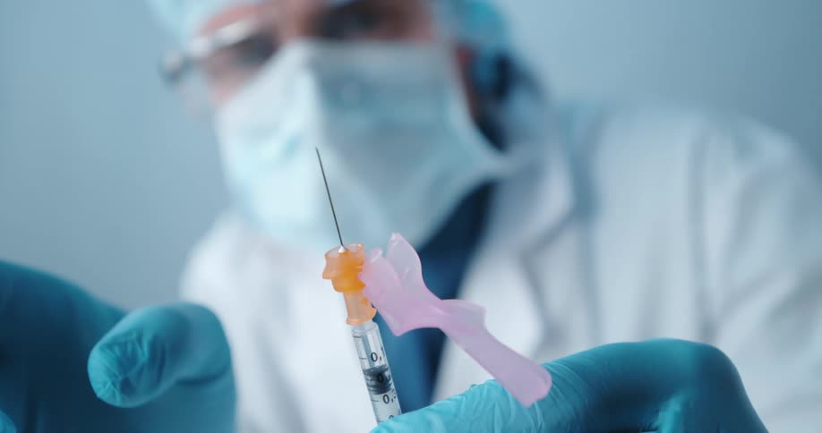 A man flicking a syringe