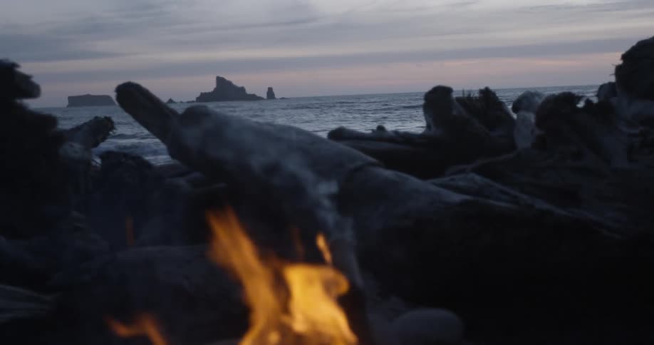 A campfire burning on a beach