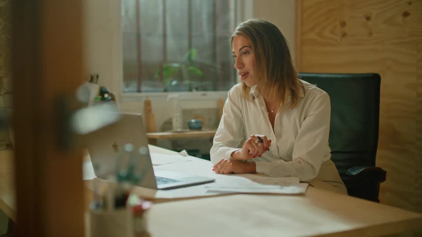 Woman attending a video call on a laptop in the office