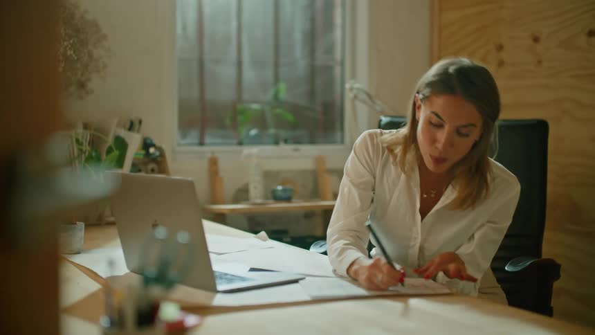 A woman is talking on a laptop and sitting indoors