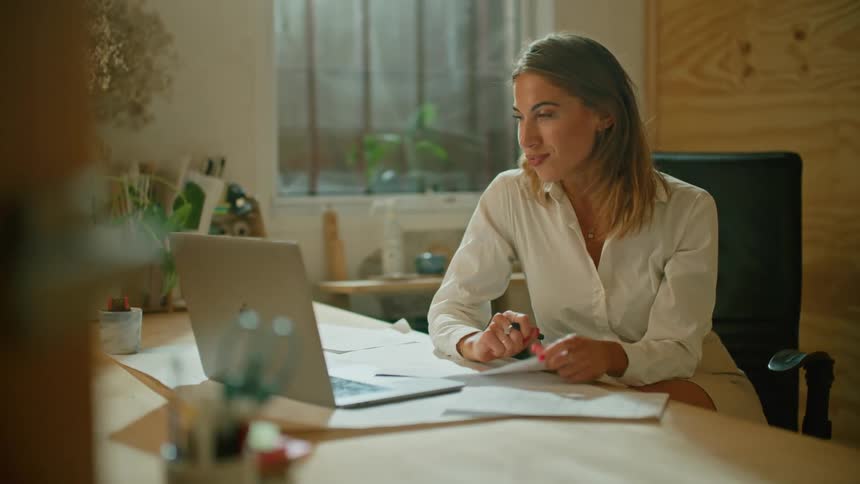 A woman talking to someone on a laptop