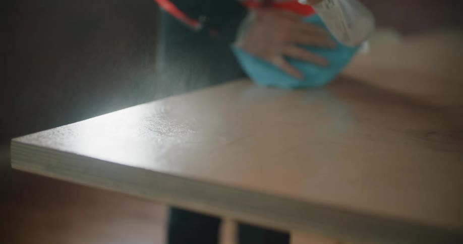 A person wiping down a table with a rag