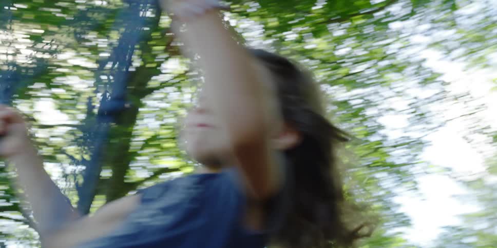 A young girl smiles as she swings outdoors