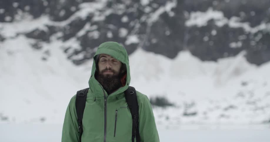 A man shakes his head and nods while standing in the snow