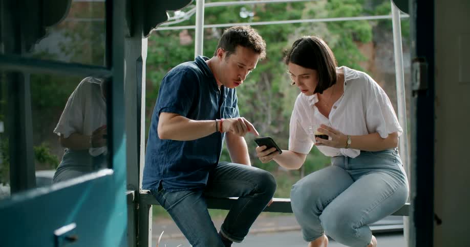 A man points out something on a womans phone