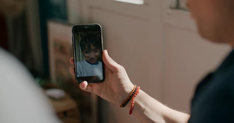 Two parents receiving a video call from their son at home
