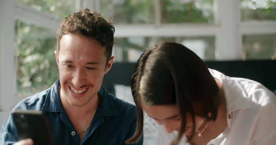 A man and woman laughing talking on a phone