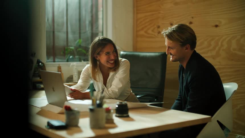 A man and woman looking at a laptop