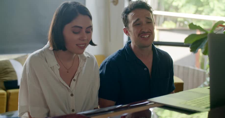 A man and woman play the piano together