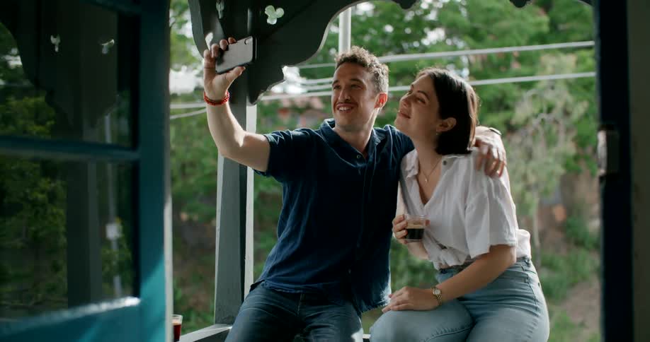 A man and woman pose for a selfie on the porch
