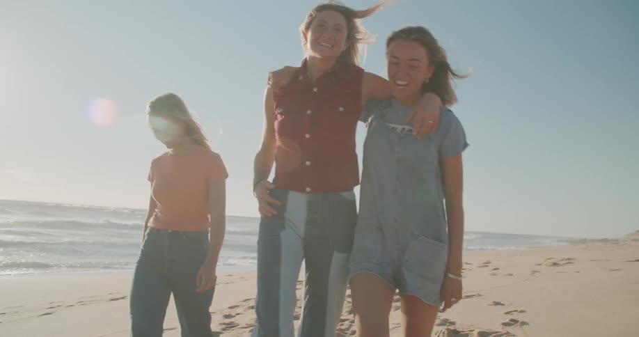 Three women walk along the beach