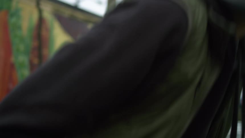 A man sitting on a bench outside puts on a mask and stands up
