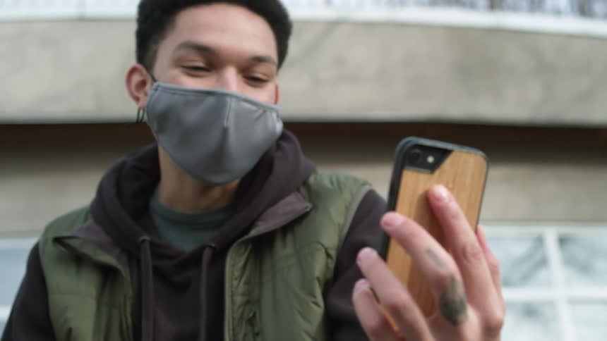 A man talking on a phone standing outside