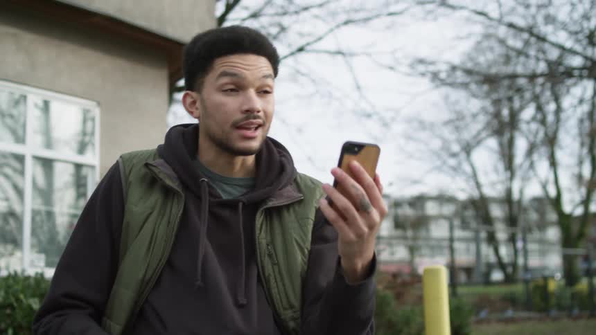A man standing outside talking to a phone