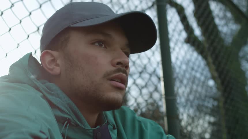 A man sitting at a fence