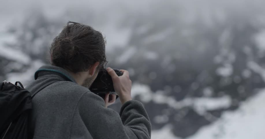 A man is taking photographs with a camera