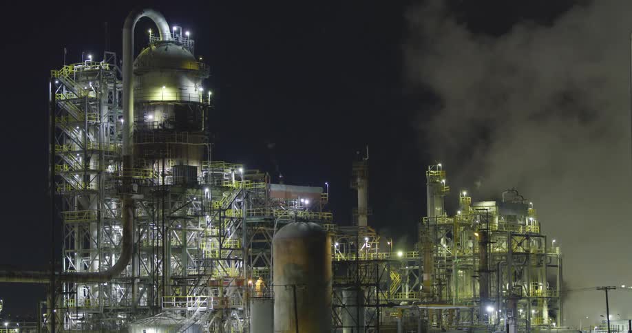A refinery with piping and smoke